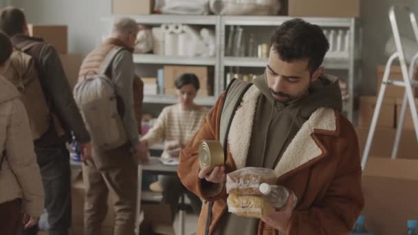 Slowmo Portrait Bearded Refugee Man Food Water Supplies Hands Looking — Stock Video