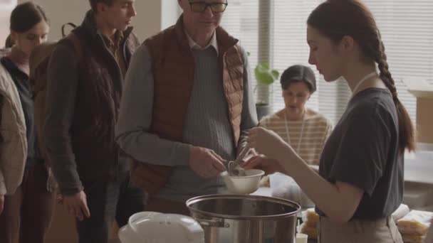 Média Lentidão Jovens Voluntárias Derramando Sopa Quente Tigelas Descartáveis Para — Vídeo de Stock