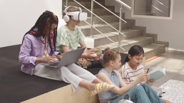 Čtyři Různorodé Školáci Neformálním Oblečení Čekají Hodiny Moderní Školní Hale — Stock video