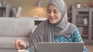 Kafiyeli mesajlaşan ya da dizüstü bilgisayarda gezinen, rahat bir oturma odasında otururken kameraya gülümseyen genç ve güzel Müslüman kadının yavaş yavaş portresini çek.