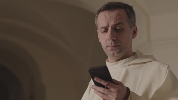 Petto Lento Fiducioso Giovane Papa Vestaglia Bianca Con Suo Smartphone — Video Stock