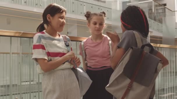 미디엄은 여학생들 평상복을 배낭을 복도에서 난간으로 채팅하는 모습을 촬영했다 — 비디오