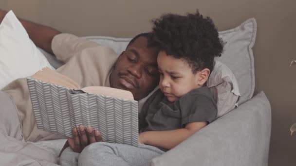 Slowmo Afroamerykanskiego Samotnego Ojca Jego Maly Syn Czytaja Ksiazke Podczas — Wideo stockowe