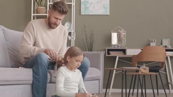 白种人单身父亲一边画着辫子 一边给他的小女儿编辫子 在家里呆着 — 图库视频影像