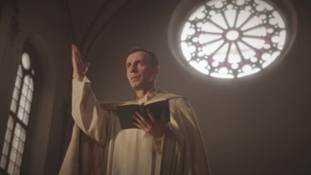 어두운 카톨릭 교회에서 설교하는 성경을 신부의 중간느린 — 비디오