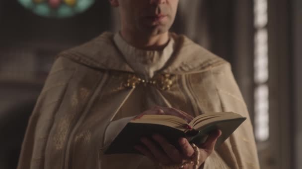 カトリック教会で聖書を読み 交差する白い子羊とマントの集中白人牧師の作物のスローモ — ストック動画