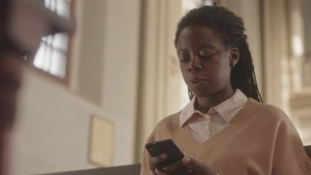 Підтримуйте Повільність Молодої Чорношкірої Жінки Допомогою Смартфона Під Час Читання — стокове відео