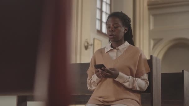 Медленно Молодая Афроамериканка Читает Молитву Смартфоне Сидя Деревянной Скамейке Католической — стоковое видео