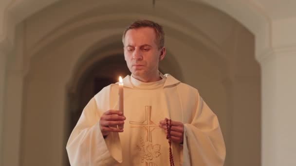 Spårning Medium Slowmo Präst Vit Mantel Håller Brinnande Ljus Och — Stockvideo