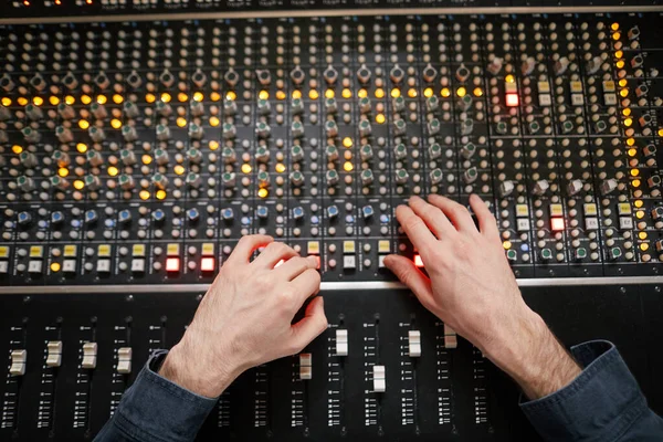 专业录音室音频工作站上男性手操作按钮和切换的顶视图背景 音乐制作主题 — 图库照片