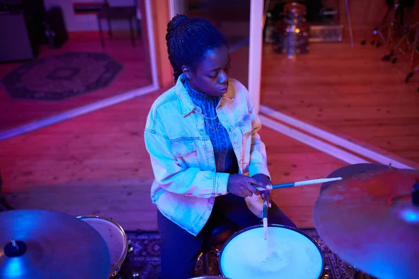 Cinematic portrait of black female drummer playing music in live studio performance, copy space