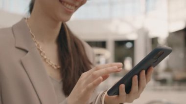 Modern alışveriş merkezinin bulanık arka planında dikilirken akıllı telefondan kayan gülümseyen esmer kadın yavaşladı.