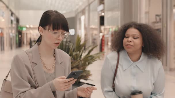 백화점에서 친구와 쇼핑을 하면서 스마트폰으로 온라인 카탈로그를 검색하고 사항을 입력하는 — 비디오