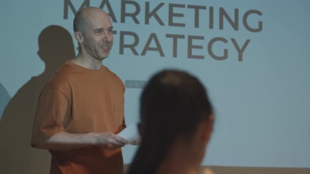 성공적 마케팅 전문가가 어두운 방에서 스크린 프로젝터를 상대로 전략에 프레젠테이션을 — 비디오