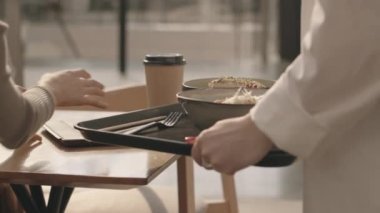 İki iş kadınına yemek servisi yapan tanınmayan garsonun orta bölüm yavaşlığı içeride yemek masasında buluşuyor.