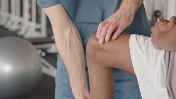 Fizioterápiás Kezelés Során Térdsérülést Szenvedett Fekete Férfi Beteg Sípcsontjának Megfigyelését — Stock videók