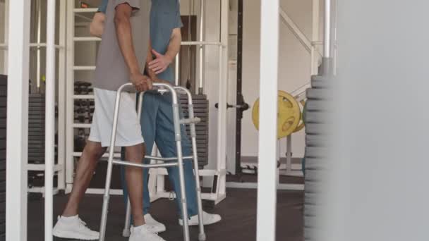 Mavi Önlüklerde Fizyoterapi Uzmanı Tarafından Desteklenen Rehabilitasyon Merkezinde Modern Spor — Stok video