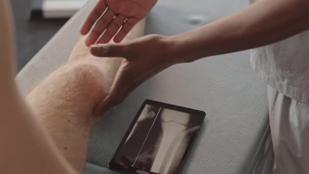 Detailní Záběr Afroamerického Fyzioterapeuta Ukazující Pacientovi Xray Holenní Kosti Tabletu — Stock video