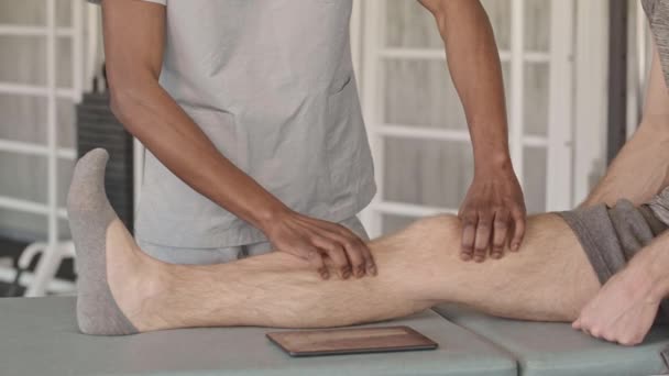 Langzame Close Van Mannelijke Afro Amerikaanse Fysiotherapeut Doet Beenmassage Aan — Stockvideo