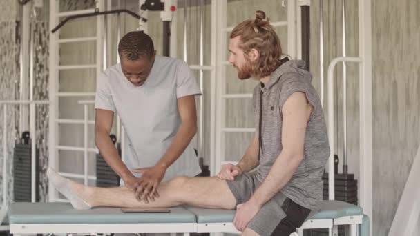 Langzame Afro Amerikaanse Fysiotherapeut Onderzoekt Het Been Van Patiënten Toont — Stockvideo