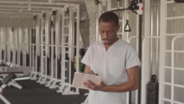 Retrato Médio Jovem Fisioterapeuta Afro Americano Uniforme Com Prancheta Olhando — Vídeo de Stock