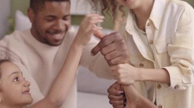 İki küçük güzel kızı olan ve evde baş parmaklarıyla tuhaf el oyunları oynayan neşeli Afro-Amerikan bir aile.