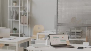 Masaüstünde takvim gereci ve yapıştırma notu olan beyaz ofis masasında yavaşlayan kimse yok