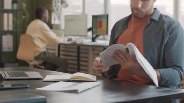 Afrikalı Amerikalı meslektaşımla modern ajansta çalışan ve finansal belgeleri okuyup analiz eden Kafkas pazarlama uzmanlarının yavaşlaması.