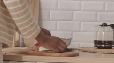 Mutfak masasında oturan sevgili erkek arkadaşı için sağlıklı kahvaltı hazırlayan tanınamaz bir kadın.