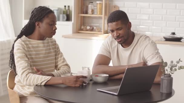 在简约的厨房里一起吃早餐时聊天的非洲裔年轻夫妇的慢动作 — 图库视频影像