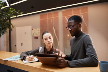 Modern ofis binasındaki çalışma salonunu tartışırken kadın meslektaşımla konuşurken çekilmiş bir portre.