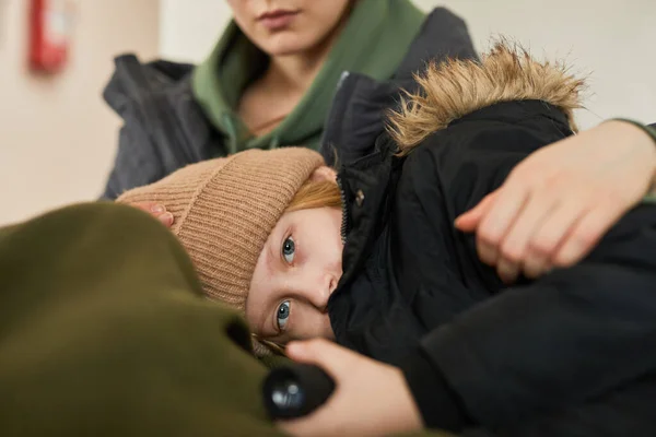 Portrait Blonde Caucasian Child Lying Mothers Lap Refugee Shelter Looking — Stock Photo, Image