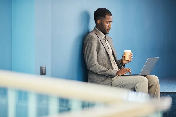 Visão Lateral Vibrante Retrato Preto Jovem Empresário Usando Laptop Enquanto — Fotografia de Stock