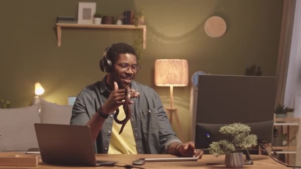 Średnie Spowolnienie Radosnego Młodego Czarnego Mężczyzny Słuchawkach Trzymającego Brązowego Węża — Wideo stockowe