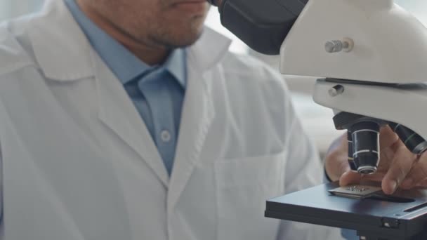 显微镜下穿着白衣的男性科学家在检查计算机芯片时的剪切速度研究 — 图库视频影像