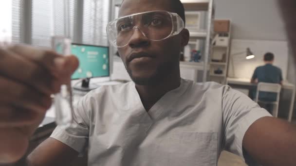 실험실에서 동료들 연구하고 시험관에 물질을 떨어뜨리는 아프리카 화학자 Pov — 비디오