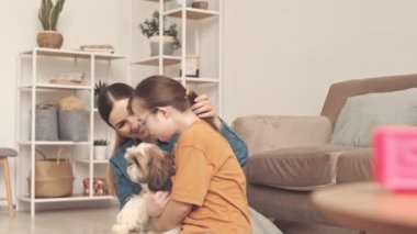 Down sendromlu küçük beyaz kız, annesi ve oynak shih tzu köpeği evde birlikteler.