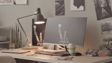 Minimalist ofis masasında bilgisayar monitörü ve duvarlarında bir sürü siyah beyaz resmi olan insanlar yok. Fotoğraf rötuşçusunun işyeri