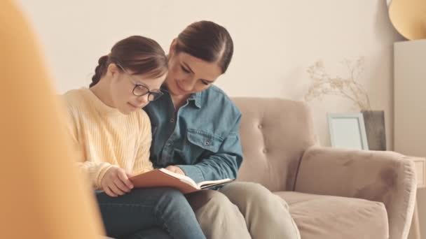 Sevgi Dolu Anne Sendromlu Kızı Oturma Odasında Oturmuş Kitap Okuyorlar — Stok video