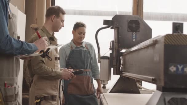 Team Young Carpenters Aprons Using Remote Control Device Operate Woodworking — Stock Video