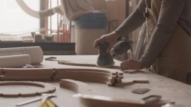 Yavaş yavaş tanınmayan erkek marangozlar atölyede yontulmuş ahşap eşyalar yapıyorlar.