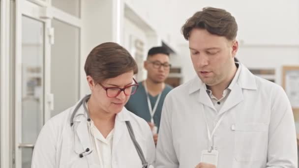 Modern Hastane Koridorunda Yürürken Konuşan Doktorların Orta Yavaşlığı Önlüklü Iki — Stok video