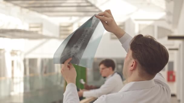 Visão Traseira Radiologista Masculino Jaleco Branco Olhando Para Imagem Raio — Vídeo de Stock