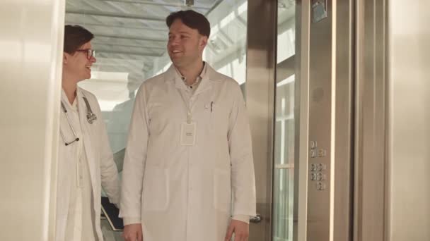 Medium Slowmo Couple Doctors White Lab Coats Having Conversation Elevator — Stock Video