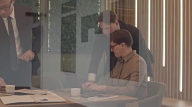 Proje üzerinde çalışan yaratıcı pazarlama ekibinin orta yavaşlığında cam duvarlı konferans odasında oturup dizüstü bilgisayar ekranına bakıyor ve tartışıyorlar.