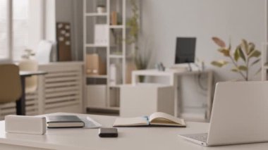 Beyaz ofis masasında dizüstü bilgisayarı ve defteri olan, İnsan Kaynakları müdürünün iş yerinde yavaşlayan hiç kimse yok.
