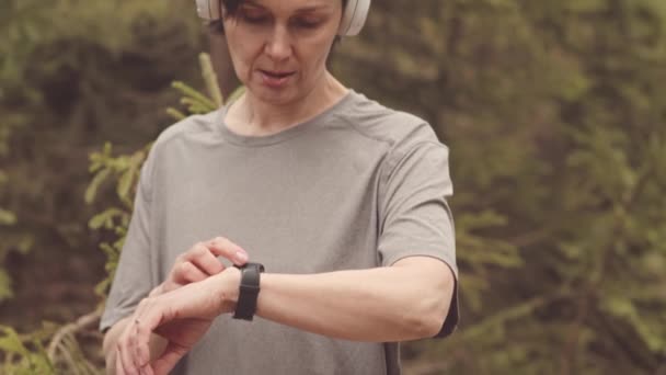 Γείρετε Μέχρι Αργή Ώριμη Καυκάσια Γυναίκα Ακουστικά Κοιτάζοντας Smartwatch Στον — Αρχείο Βίντεο