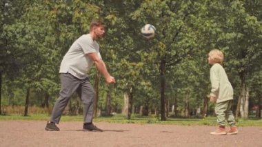 Babasıyla küçük oğlunun yaz günü parkta voleybol oynaması uzun sürdü.