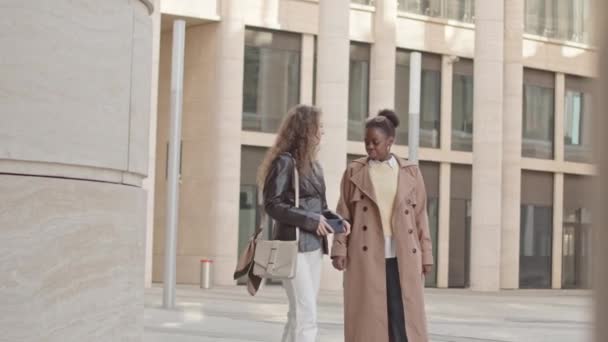昼間に街を歩いている2人の若い多民族女性のスローモ どこへ行くかを決定しながら スマートフォン上のナビゲーションアプリを見て — ストック動画