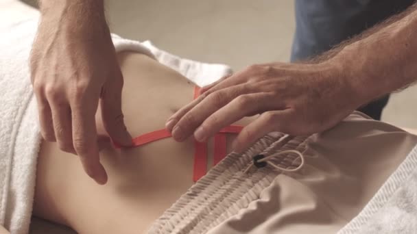 Slowmo Des Unkenntlichen Männlichen Chiropraktikers Der Kinesiobänder Bauch Der Jungen — Stockvideo
